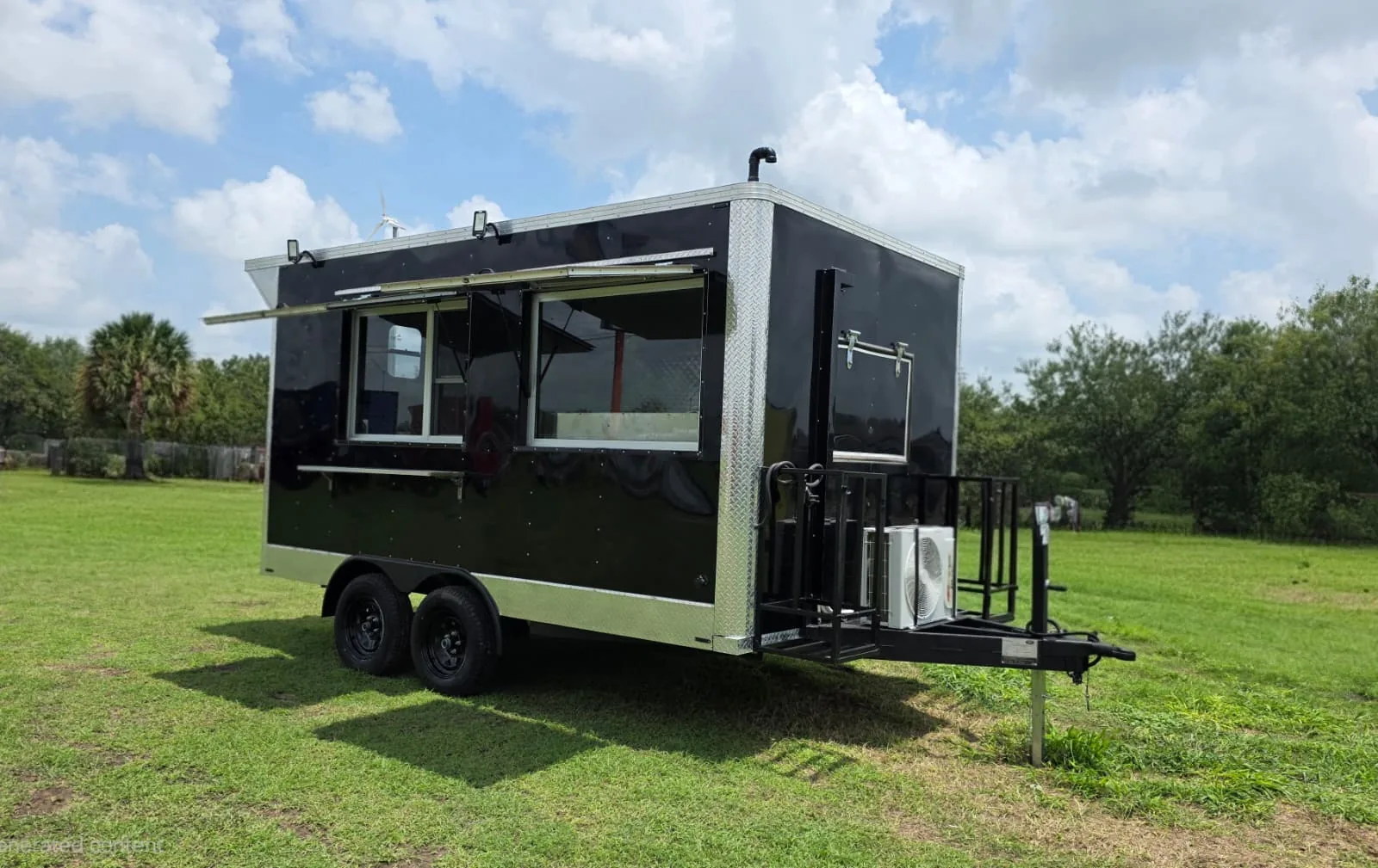 Black Carranza food trailer exterior with open serving windows and a front platform